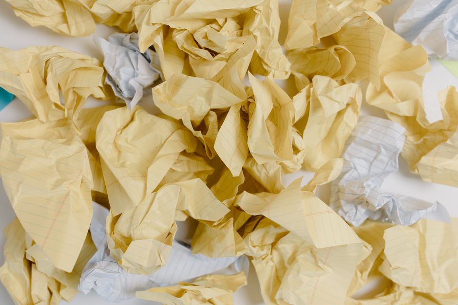 A close-up view of crumpled and flattened aluminum beverage cans, including brands such as Pepsi and other soft drinks, scattered and overlapped on a surface. The cans display various colors like silver, blue, red, yellow, and black, with some labels partially visible. The metallic surfaces show dents, scratches, and creases from prior use. This image depicts materials commonly involved in recycling and waste sorting, relevant to house removals and packing processes handled by Man With a Van Cranford. The cans are likely prepared for recycling or disposal during a home relocation or waste management task, with no other furniture or packaging materials present in the image, emphasizing the need for proper waste separation during moving services.
